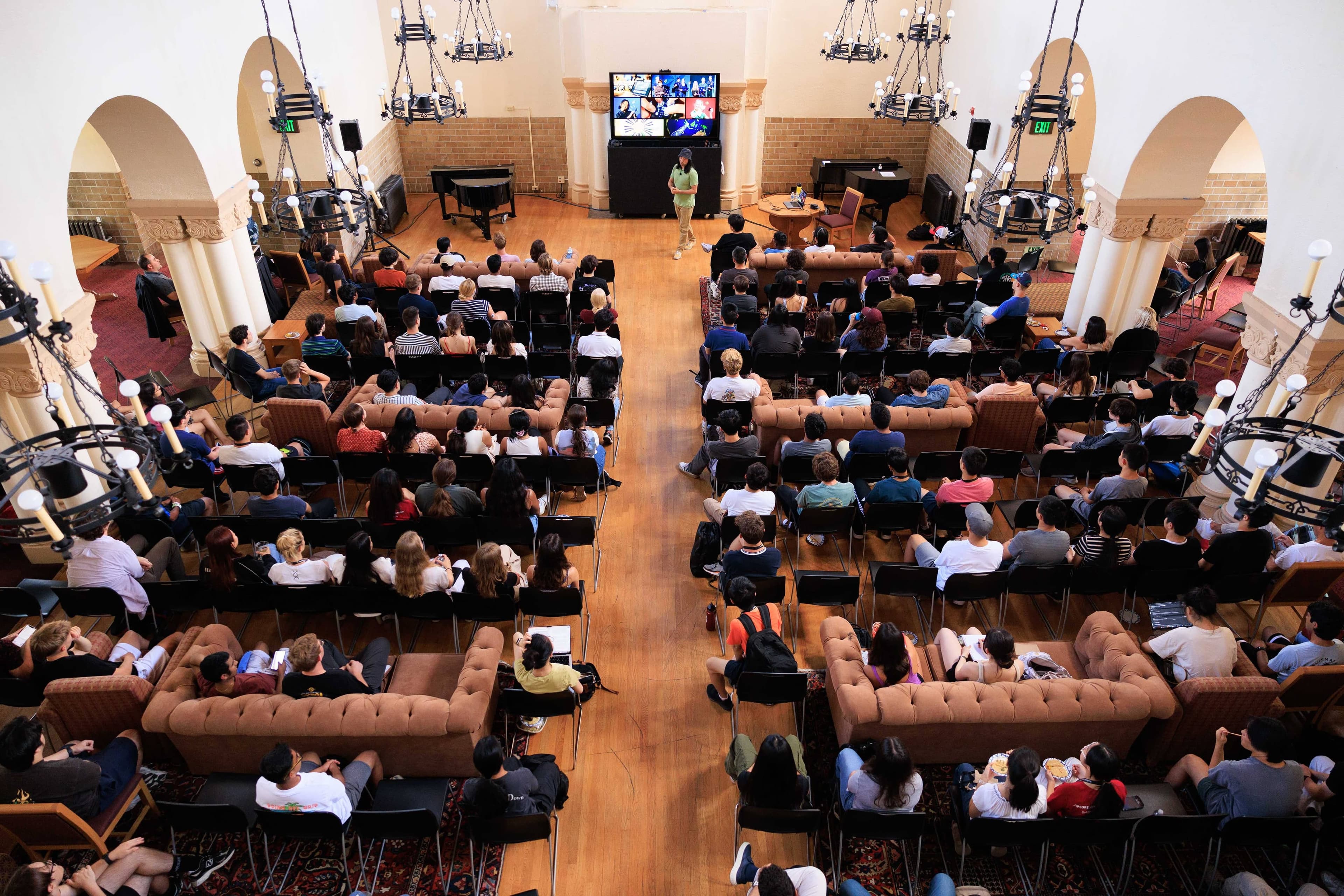 Students sit on sofas to hear Professor Ge Wang.